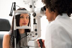 A woman at an eye exam appointment with an optometrist.