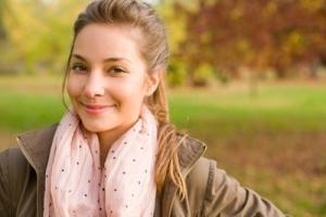 A woman smiling outdoors.