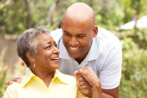 An elderly mom smiling at her son.