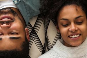 A man and woman laying down and reading a book.