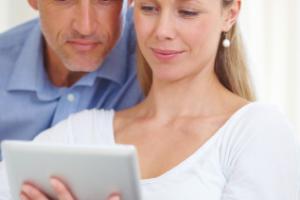 A mature couple looking at a tablet.