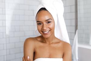 A woman in her bathroom at home with a towel wrapped around her head.