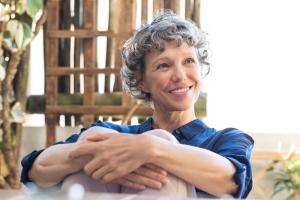 A senior woman smiling outdoors.