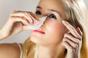 A woman applying eye drops.