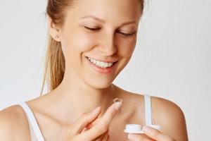 woman holding contact lens and its case.