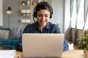 woman wearing a headset and working on her laptop. 