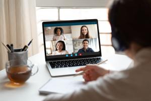 person on a video call with four others on laptop. 