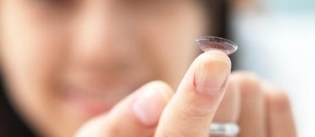 woman holding contact lens