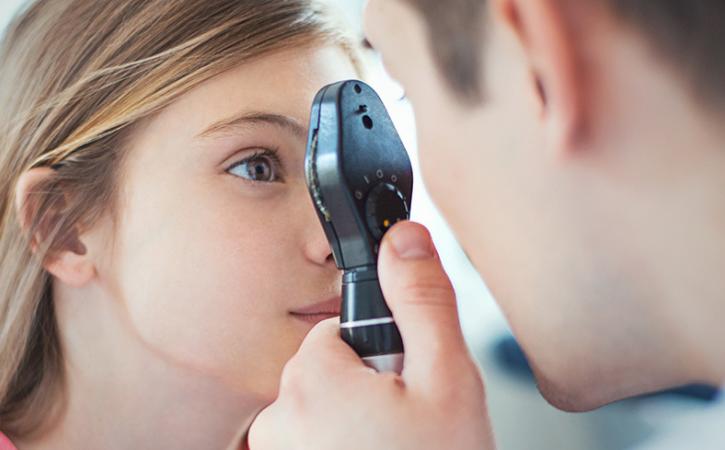 Optometrist examining patient&#039;s eye.